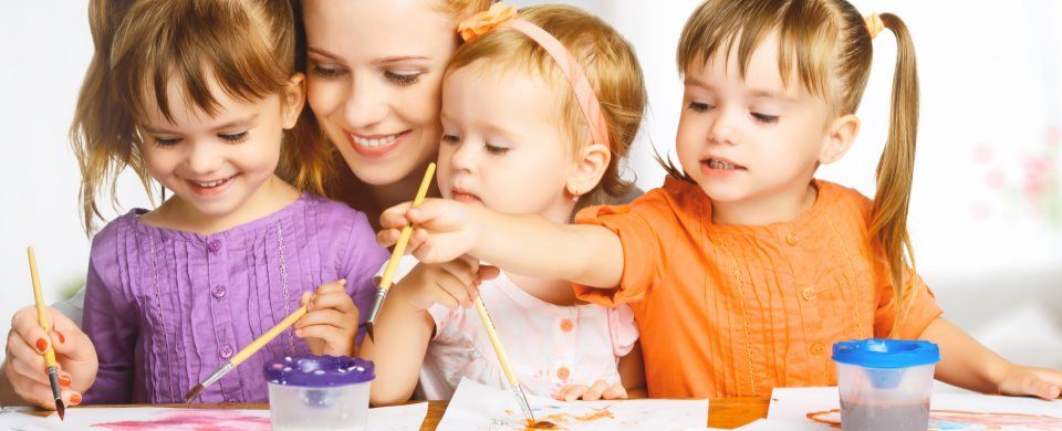 Erzieherin malt gemeinsam mit Kindern